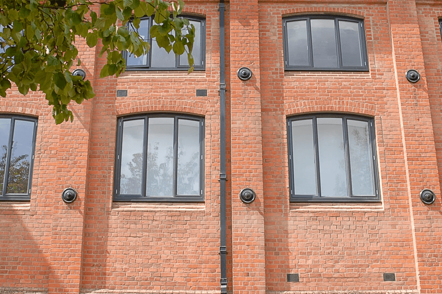 grey aluminium windows on large orange brick house